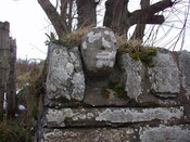 49. Larger carved stone face set on top of front wall at ext.JPG